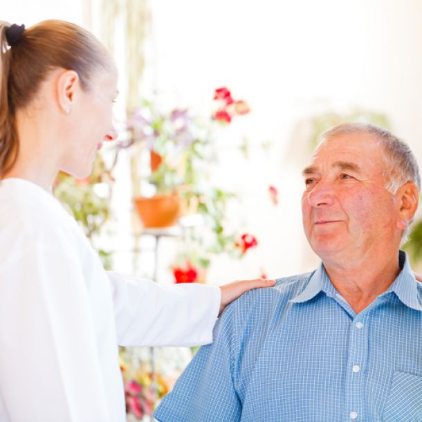 Senior schaut junge Dame im Pflegedienst an